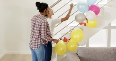 Çeşitli aileler evlerinde merdivenleri dekore ediyor, balon patlatıyor, konfeti dağıtıyor ve sarılıyorlar. Kutlama, neşe, şenlik, bağ, ev dekorasyonu, coşku, mutluluk.