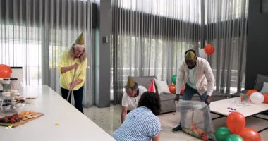 Konfeti ve balon temizleme, partiden sonra ofisleri toplayan mutlu meslektaşlar. Temizlik, kutlama, takım çalışması, neşe, işbirliği, dekorasyon