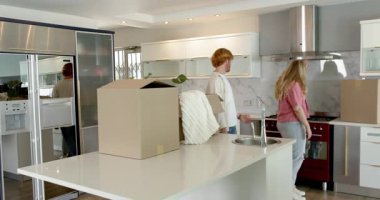 Mutlu çift ev turu yapıyor, mutfakta yürüyor, içeriden bahsediyor, gülümsüyor. Taşınmak, konut ve ev hayatı kavramı.