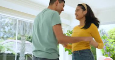 Genç çift evde neşeyle dans ediyor, mutlu anlarını paylaşıyorlar. Dans, romantizm, mutluluk, yaşam tarzı, ilişki