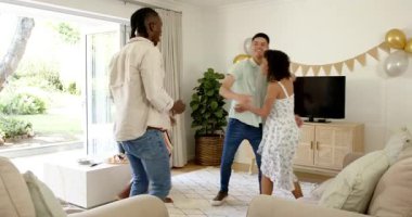 Çeşitli arkadaşlar partiyi modern bir odada kutluyor, lezzetli atıştırmalıkların ve balonların tadını çıkarıyorlar. Kutlama, arkadaşlar, toplanma, modern, hareketli, sosyalleşme, atıştırmalıklar.