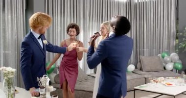 Mutlu gelin, damat ve farklı arkadaşlar oturma odasındaki düğün resepsiyonunda maytap tutuyorlar. Kutlama, düğün, ilişki, parti ve arkadaşlık kavramı.