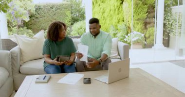 Olgun çift belgeleri gözden geçirir ve verandada dizüstü bilgisayar kullanır, mali konuları tartışır. Emeklilik, mali planlama, yatırım, bütçe, son sınıf, teknoloji