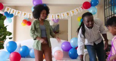 Mutlu siyah çift ve onların çok ırklı oğulları oğullarının doğum gününü evde kutluyorlar. Doğum günü, kutlama, parti, aile, çocukluk, ev hayatı ve ilişki kavramı.