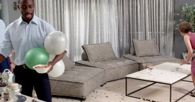 Mutlu damat ve farklı arkadaşlar oturma odasındaki düğün töreninden sonra temizlik yapıyorlar. Kutlama, düğün, ilişki, parti ve arkadaşlık kavramı.