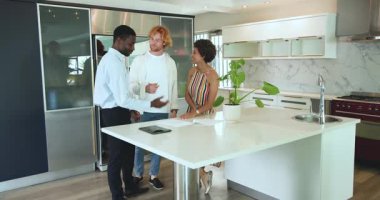 Mutlu ve çok ırklı bir çift ve zenci bir emlakçı ev turu yapıyor, konuşuyor, kontrat imzalıyor ve el sıkışıyor. Taşınmak, konut ve ev hayatı kavramı.