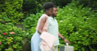 Genç çift çimenlerde neşeyle dans ediyor, el ele tutuşuyor ve birlikte gülümsüyor. Açık hava, dans, mutluluk, romantizm, aşk