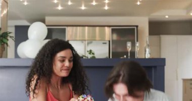 Konfeti atan ve oturma odasındaki yıldönümü partisinde kutlama yapan mutlu çift. Kutlama, yıldönümü, ilişki, parti ve yaşam tarzı konsepti.