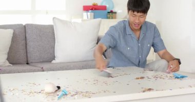 Adam, evinde kutlama yapmak için renkli balonlarla oturma odasını dekore ediyor. Dekorasyon, şenlik, parti, iç mekan, mutluluk