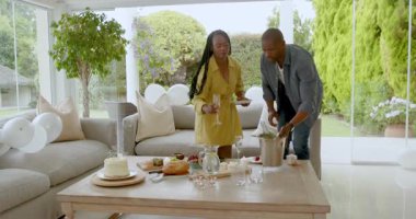 Afro-Amerikalı adam evinde kutlamaya hazırlanıyor, elinde buz kovası var. parti, hazırlık, şenlik, eğlence, yemek, yaşam tarzı