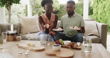 Genç çift verandada kek ve meyvenin tadını çıkarıyor, anı paylaşıyorlar. Romantizm, mutluluk, açık hava, ilişki, tatlı, atıştırmalık