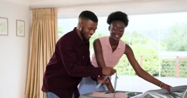 Afro-Amerikalı çift evde bavullarını topluyor, birlikte tatile hazırlanıyorlar. Seyahat, hazırlık, macera, turizm, ilişki, yaşam tarzı