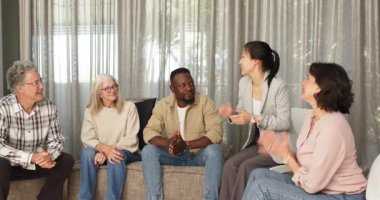 Klinikte, kadın terapist erkek hastaya sertifika verirken diğerleri izliyor. Kutlama, başarı, terapi, tanınma, rehabilitasyon, ilerleme