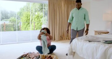 Birlikte bavul hazırlıyoruz, olgun bir çift rahat yatak odasında tatile hazırlanıyor. Seyahat, bagaj, hazırlık, ev, yaşam tarzı, birliktelik