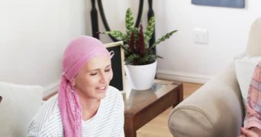 Son sınıf öğrencisi kadın eve pasta yerleştiriyor mumları üflüyor ve doğum gününü kutlayan arkadaşları için pasta kesiyor. Kutlama, dostluk, sıcaklık, konforlu, yaşlı, kırsal, mutluluk