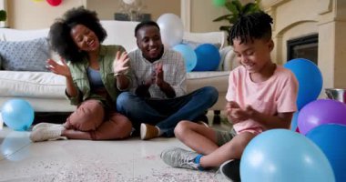Mutlu siyah çift ve onların çok ırklı oğlu gülümseyerek parti veriyor, çocuğun doğum gününü evde kutluyorlar. Doğum günü, kutlama, parti, aile, çocukluk, ev hayatı ve ilişki kavramı.