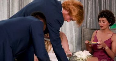 Mutlu gelin ve damat ve farklı arkadaşlar oturma odasındaki düğün resepsiyonunda yemek yiyorlar. Kutlama, düğün, ilişki, parti ve arkadaşlık kavramı.