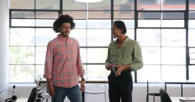 İki farklı erkek meslektaşımız ofis eşyalarıyla dolu kutuları ve yeri tanıtıyorlar. Takım çalışması, iş ve iletişim konsepti.