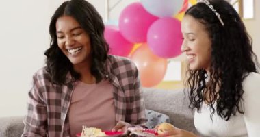 Çeşitli bayan arkadaşlar 18. doğum gününü oturma odasında kırmızı kadife kek ve atıştırmalıklar göstererek kutluyorlar. Parti, kilometre taşı, genç, enerjik, neşeli, şekerleme, atıştırmalık