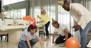 Ofis salonundaki partiden sonra konfeti ve dekorasyon temizleyen mutlu meslektaşlar. Kutlama, eğlence, birliktelik, ofis partisi ve iş konsepti.