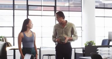 İki mutlu meslektaş birlikte çalışmayı tartışıyor ve bir ofiste kutudan bir şeyler çıkartıyorlar. Takım çalışması, iş ve iletişim konsepti.