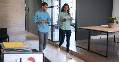 İş arkadaşlarınız mutlu yürüyüşler, akıllı telefon kullanmalar, kucaklaşmalar ve ofiste kutlamalar. takım çalışması, iş, kutlama ve iletişim konsepti.