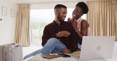 Pasaportları olan genç bir çift, dizüstü bilgisayarla yatmayı planlıyor. yolculuk, macera, dijital göçebe, rahatlama, hazırlık, teknoloji