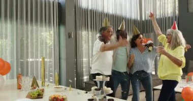 Birlikte kutlayan, dans eden, konfeti atan ve ofiste kucaklaşan farklı meslekdaşlar. Kutlama, eğlence, birliktelik, ofis partisi ve iş konsepti.