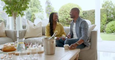 Çift evde kutlama yapıyor, şampanya açıyor ve birlikte mutlu anların tadını çıkarıyor. Kutlama, aşk, mutluluk, birliktelik, tost, ilişki