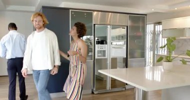 Mutlu, çift ve erkek emlakçı ev turu yapıyor, konuşuyor ve kontrat imzalıyor. Taşınmak, konut ve ev hayatı kavramı.