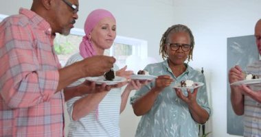Çeşitli son sınıf arkadaşları pasta dilimlerini çatalla kesiyor ve evde kanser hastalarını işaretliyor. Kutlama, dostluk, yaşlanma, yoldaşlık, pozitiflik, refah, yurtiçinde