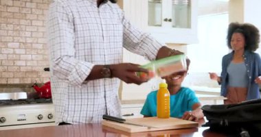 Mutlu siyah çift ve onların çok ırklı oğlu evde okula gitmek için mutfakta yemek hazırlıyorlar. Eğitim, okul, aile, çocukluk, ev hayatı ve ilişki kavramı.