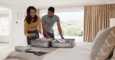 Genç çift yataklarına bavullarını topluyor, evde birlikte tatile hazırlanıyorlar. Seyahat, bagaj, hazırlık, yolculuk, yolculuk