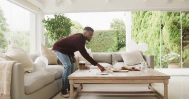 Genç çift sıcak oturma odasında kahvelerini yudumluyor, kahkahalarını paylaşıyorlar. sohbet, bağ, ilişki