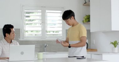 Asyalı baba ve oğul modern mutfaktaki belgelerle başarıyı kutluyorlar. Aile, mutluluk, yaşam tarzı, babalık, ebeveynlik, bağlılık