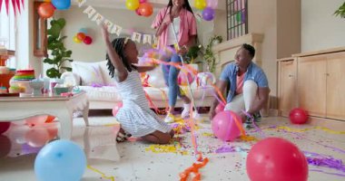 Mutlu siyah çift ve kızları, kızın doğum gününü evde kutladıktan sonra temizlik ve temizlik yapıyorlar. Doğum günü, kutlama, parti, aile, çocukluk, ev hayatı ve ilişki kavramı.