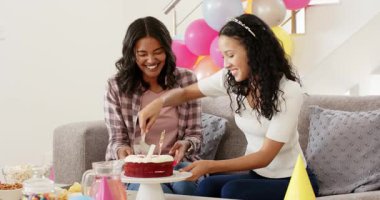 Pasta servisi yapan bir kadın, gençlerin doğum gününü kutlamak için oturma odasında kırmızı kadife dilimliyor. Şen, dostluk, kutlama, neşeli, canlı, yoldaş, neşeli
