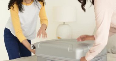 Çeşitli anne ve genç kızlar gümüş bavullarını topluyor, beyaz kurdeleli hediye kutusunu yatakta açıyorlar. Aile, bağlılık, şefkat, kutlama, hazırlık, jest, minnettarlık.