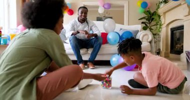 Mutlu siyah çift ve onların çok ırklı oğulları balo düzenliyor ve gülümsüyor, çocuğun doğum gününü evde kutluyorlar. Doğum günü, kutlama, parti, aile, çocukluk, ev hayatı ve ilişki kavramı.