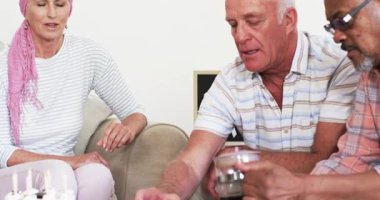 Çeşitli yaşlılar kanserden kurtulma işareti okuyor, Fransız basınından kahve dolduruyor, kanepede kadeh kaldırıyor. Destek grubu, kutlama, arkadaşlık, refah, esneklik, yoldaşlık, neşe