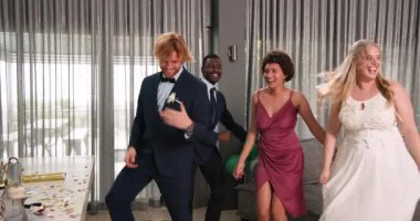 Mutlu gelin ve damat ve çeşitli arkadaşlar oturma odasında bir düğün resepsiyonunda dans ediyorlar. Kutlama, düğün, ilişki, parti ve arkadaşlık kavramı.