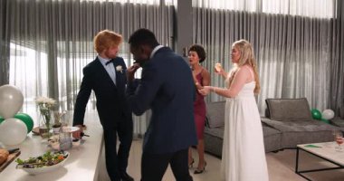 Mutlu gelin, damat ve farklı arkadaşlar oturma odasındaki düğün resepsiyonunda maytap tutuyorlar. Kutlama, düğün, ilişki, parti ve arkadaşlık kavramı.