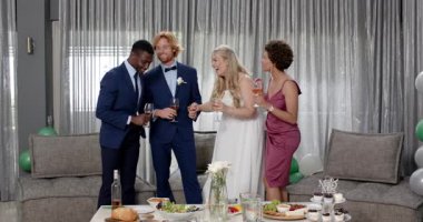 Mutlu gelin, damat ve arkadaşları oturma odasındaki düğün resepsiyonunda kadeh kaldırıyor. Kutlama, düğün, ilişki, parti ve arkadaşlık kavramı.