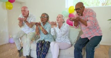 Farklı son sınıf arkadaşları konfeti kepçelerken duş alırken koltukta balonlarla alkış üstüne dans ediyor. Kutlama, dostluk, neşe, eğlence, şenlik, yaşam tarzı, dekor