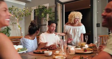 Kutlama yemeği partisinde masanın etrafında kadeh kaldıran çeşitli arkadaşlarınız kutlu olsun. Kutlama, akşam yemeği, yaşam tarzı, birliktelik ve arkadaşlık konsepti..