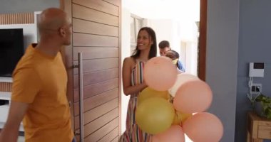 Bir grup mutlu çok ırklı ve siyahi erkek ve kadın arkadaş bir partide selamlaşıp hediyeler veriyorlar. Kutlama, parti, yaz ve arkadaşlık konsepti.