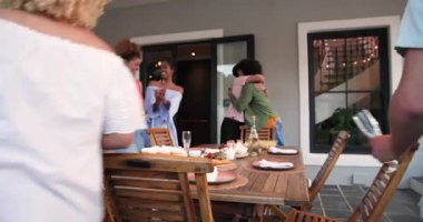 Nişan kutlaması için masa hazırlayan farklı arkadaşlar ve yüzük gösteren bir kadın. Kutlama, nişan, akşam yemeği, yaşam tarzı ve arkadaşlık konsepti.