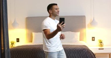 Mutlu kadın ve erkek partneri akıllı telefondan görüntülü sohbet, yatak odasında nişan yüzüğü gösteren kadın. Nişan, aile hayatı, aşk, mutluluk, yaşam tarzı ve ilişki kavramı.