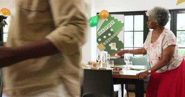 Oturma odasındaki emeklilik partisinde çok ırklı, beyaz ve siyah erkek ve kadın arkadaşlardan oluşan mutlu bir grup. Kutlama, emeklilik, parti, son sınıf yaşam tarzı ve arkadaşlık kavramı.