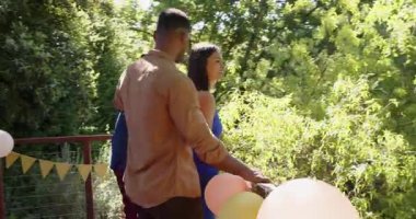 Bir grup mutlu çok ırklı ve siyah erkek ve kadın arkadaş güneşli bir günde terasta evlenme ve kutlama yapıyorlar. Kutlama, nişan, parti, yaz ve arkadaşlık kavramı.